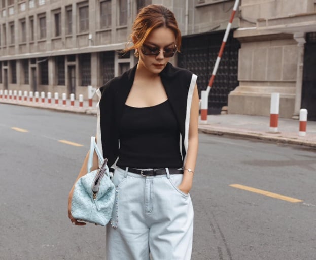 Combo áo tank top đen và quần jeans xanh ấn tượng hơn khi thêm khăn quàng vai. 