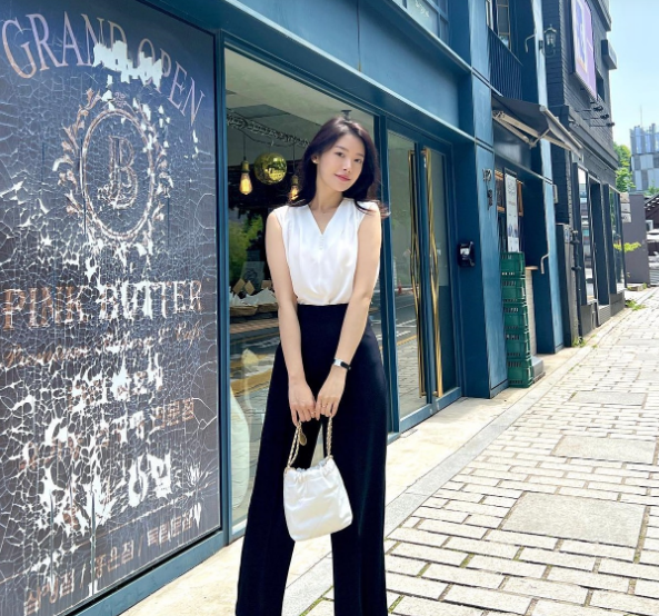 Công thức áo sát nách màu trắng và quần đen ống suông gây ấn tượng ở sự phóng khoáng, trẻ trung. 