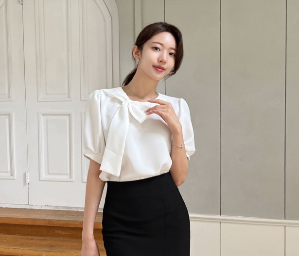 Quý cô trên 40 tuổi hãy kết hợp áo blouse gắn nơ to bản với chân váy bút chì, tông màu đen.