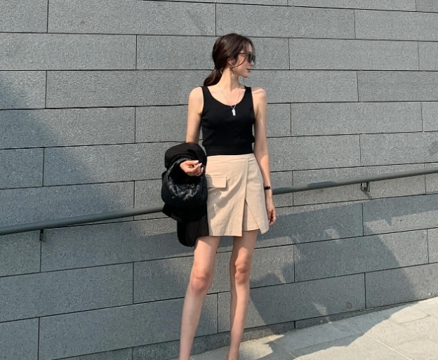 Trẻ trung và hiện đại là những ưu điểm của set đồ gồm áo tank top đen kết hợp cùng chân váy màu be.     