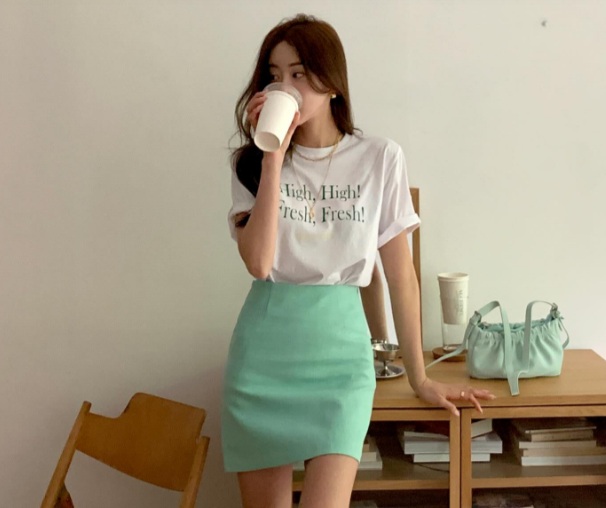 Công thức gồm áo thun in chữ kết hợp với chân váy xanh pastel.