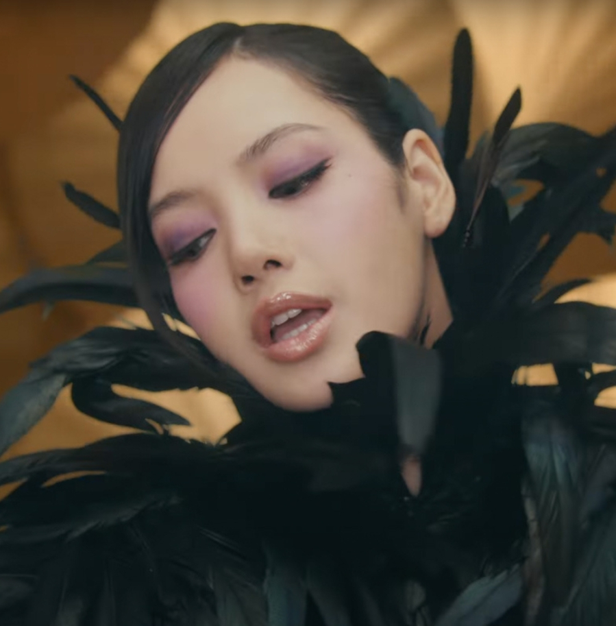 Lisa tô điểm màu tím trên mí mắt và gò má, trong khi tạo Link Vào SHBET88 Mới Nhất búi cao gọn gàng.
