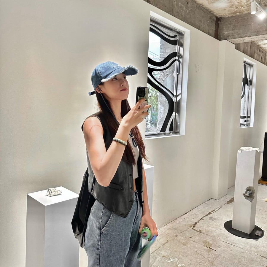 Áo gile vải da và áo crop top trắng, quần jeans xanh đã tạo nên tổng thể Shbet999 com đăng nhập cá tính nhưng không kém phần quyến rũ.    