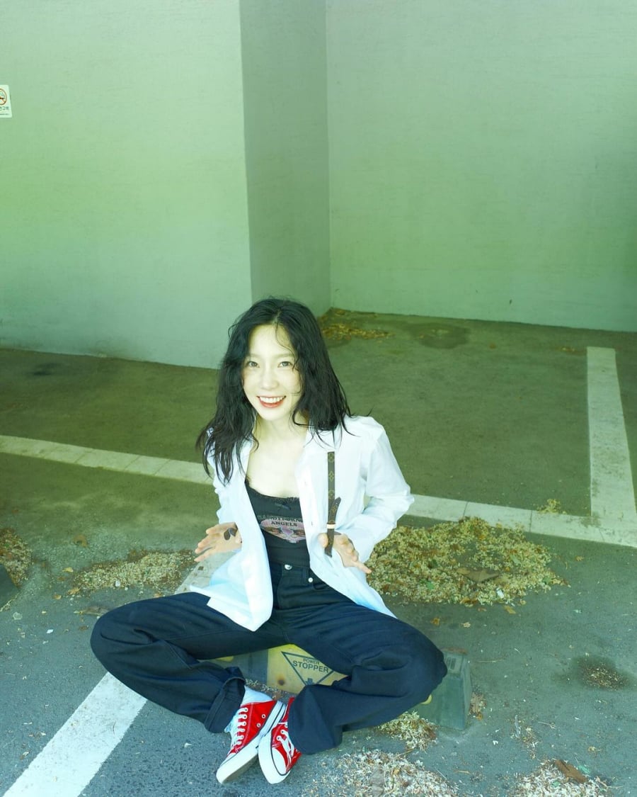 Taeyeon chọn cho mình bộ Shbet999 com đăng nhập đơn giản gồm áo dây đính nơ, quần jeans đen ống suông khoác áo sơmi bên ngoài