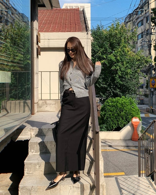 Áo cardigan màu xám mix cùng chân váy dài và đi giày cao gót mũi nhọn để tạo nên bộ đồ sang chảnh, nữ tính. 