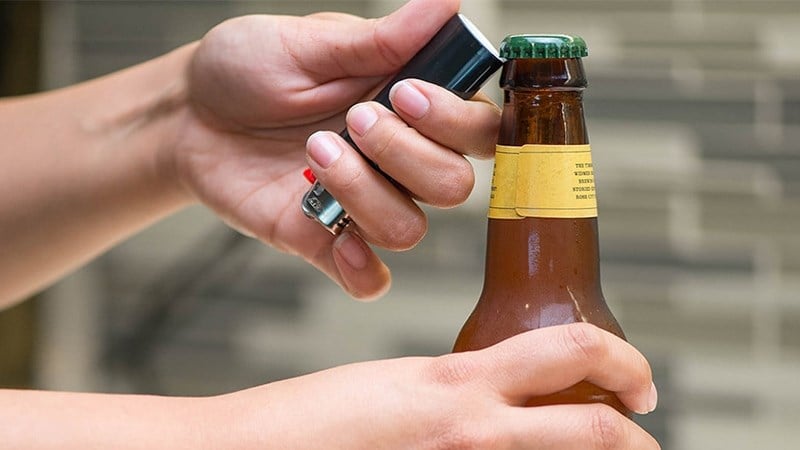 Bạn có thể đưa đuôi của bật lửa vào dưới các răng của nắp chai bia và giữ chai bia chắc chắn bằng tay không thuận sau đó dùng ngón tay cái làm đòn bẩy. 