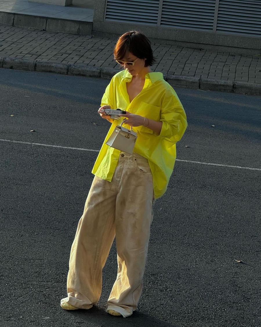 Một chiếc quần kaki dáng đứng kết hợp với áo sơ mi trắng, vàng hoặc áo blouse, có thể thêm áo blazer màu sắc trung tính như xanh navy hoặc xám