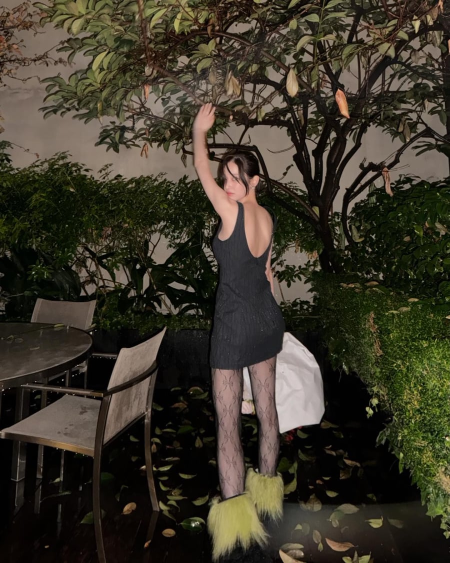 Cô nàng khoe vóc dáng đáng mơ ước với chiếc mini dress thanh lịch, với điểm nhấn là quần tất ren đen quyến rũ cùng đôi boots lông vũ xanh brat “độc lạ”.