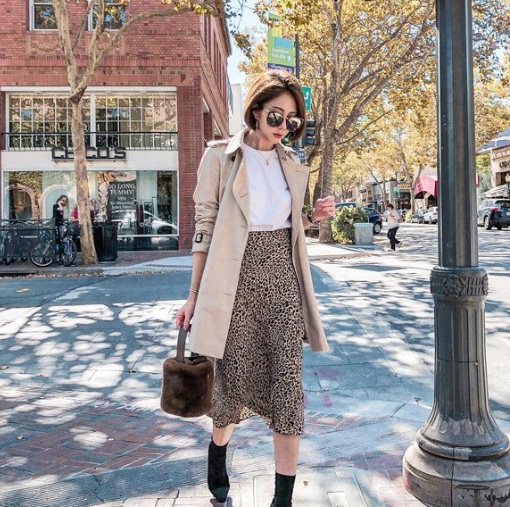 Khi kết hợp chân váy da báo với áo thun trắng, rồi khoác ngoài chiếc trench coat lại có thể tạo nên một set đồ hoàn hảo cho các nàng công sở.    