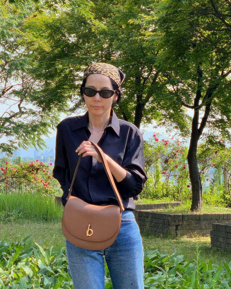 Kim Na-young diện đồ tối giản gồm sơmi xanh navy và quần jeans cơ bản, nữ diễn viên vẫn có thể “chiếm trọn spotlight” với chiếc khăn họa tiết thời thượng.
