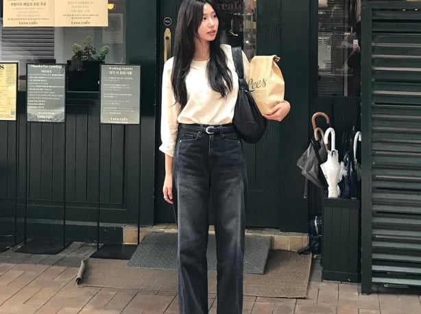 Combo áo trắng và quần jeans đen ống suông thêm thắt lưng da và đôi sandal màu đen đảm bảo thanh lịch.