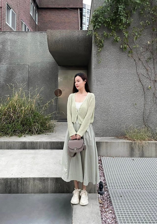 Sự phối hợp giữa áo cardigan xanh lá nhạt, chân váy cùng tông và áo trắng hoa nhí đã giúp Midu ghi điểm tuyệt đối.