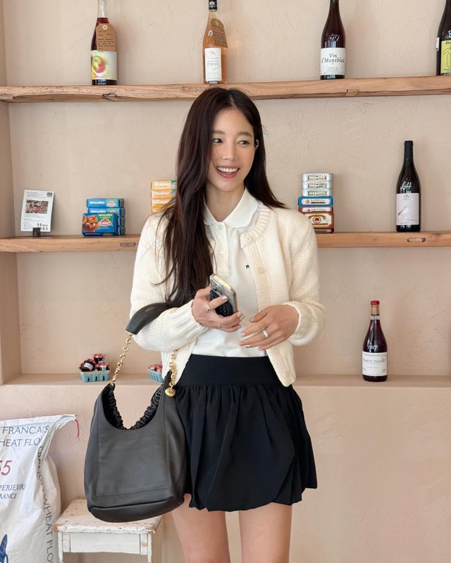 Để tôn dáng, cô khéo léo sơ vin và hoàn thiện bằng túi xách đen, tạo sự cân đối cho tổng thể.