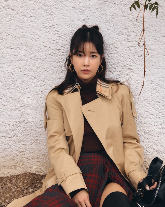 Cô thêm áo trench coat màu be để tạo sự cân bằng và tăng độ sang trọng.    