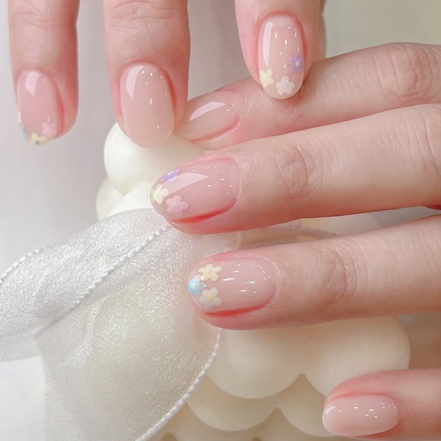 Mẫu nail này sử dụng màu nền nude nhạt và vẽ những bông hoa nhỏ tinh tế. 