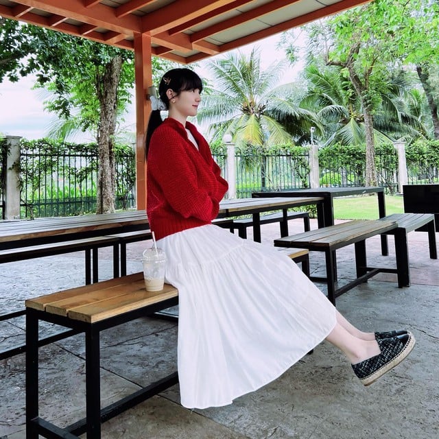 Hải Tú đã khéo léo phối áo cardigan màu đỏ với váy trắng