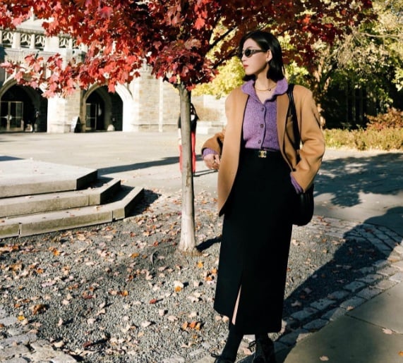 Một chiếc áo blazer kết hợp với áo len tím và chân váy suông mang đến một vẻ ngoài sang trọng