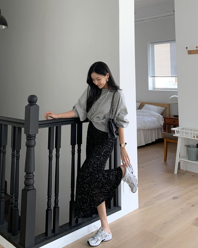 Áo nỉ màu xám với chân váy kim tuyến tạo nên một outfit thu hút ánh nhìn.