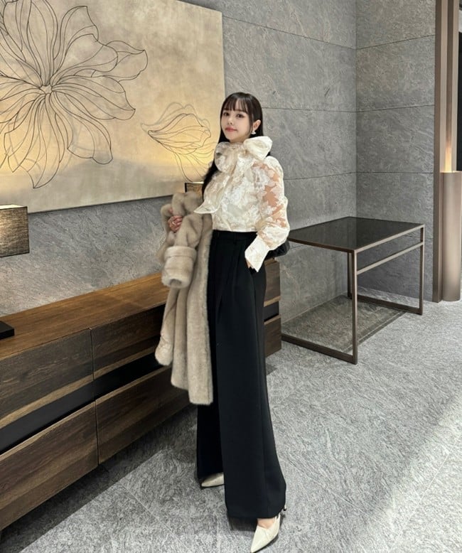 Áo blouse trắng với chi tiết thắt nơ to bản kết hợp cùng quần ống rộng màu đen tạo nên tổng thể thanh lịch