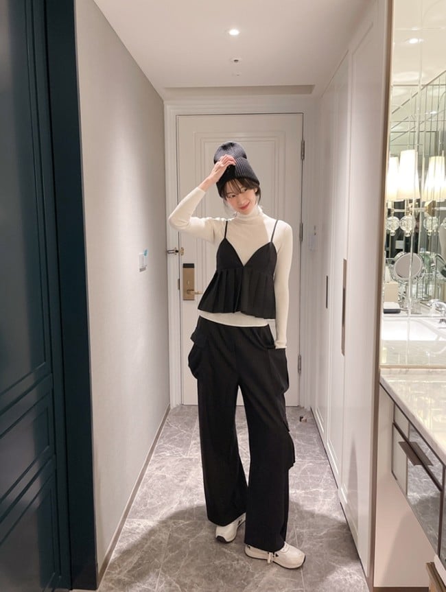 Phụ kiện như mũ beanie đen và sneaker trắng giúp tăng thêm phần phong cách.
