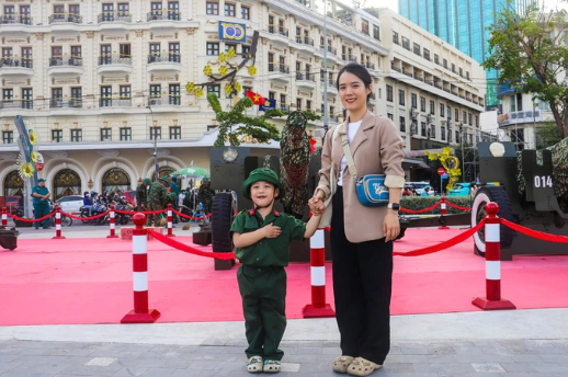 Chị Ngân Giang cùng con trai chụp hình với dàn pháo