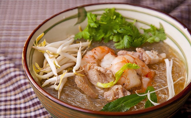 Trong một nồi đất, xếp miến xuống đáy, đặt tôm và nấm lên trên. 