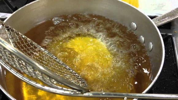 Trường hợp dầu không chỉ có cặn mà còn ám mùi khét, hãy đun nóng dầu rồi cho cơm nguội vào chiên. Khi cơm vàng giòn thì vớt ra, sau đó lọc dầu lại để loại bỏ vụn cơm.    