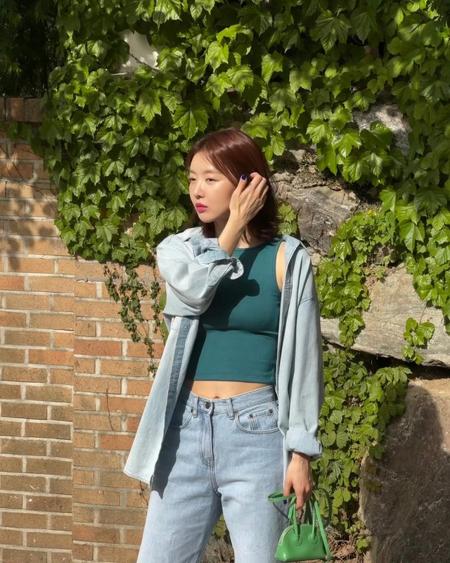 Điểm nhấn cuối cùng là một chiếc túi xách xanh, giúp outfit càng thêm nổi bật và tràn đầy sức sống.