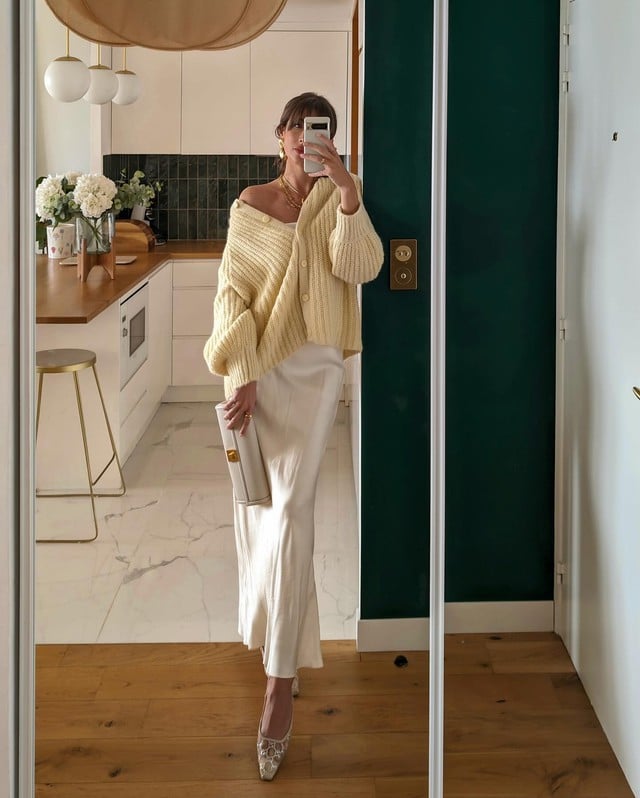 Với những ai yêu thích phong cách nhẹ nhàng, sự kết hợp giữa áo cardigan màu kem và chân váy lụa trắng là lựa chọn hoàn hảo.