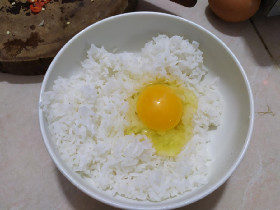 Trộn đều cơm với trứng trước khi rang