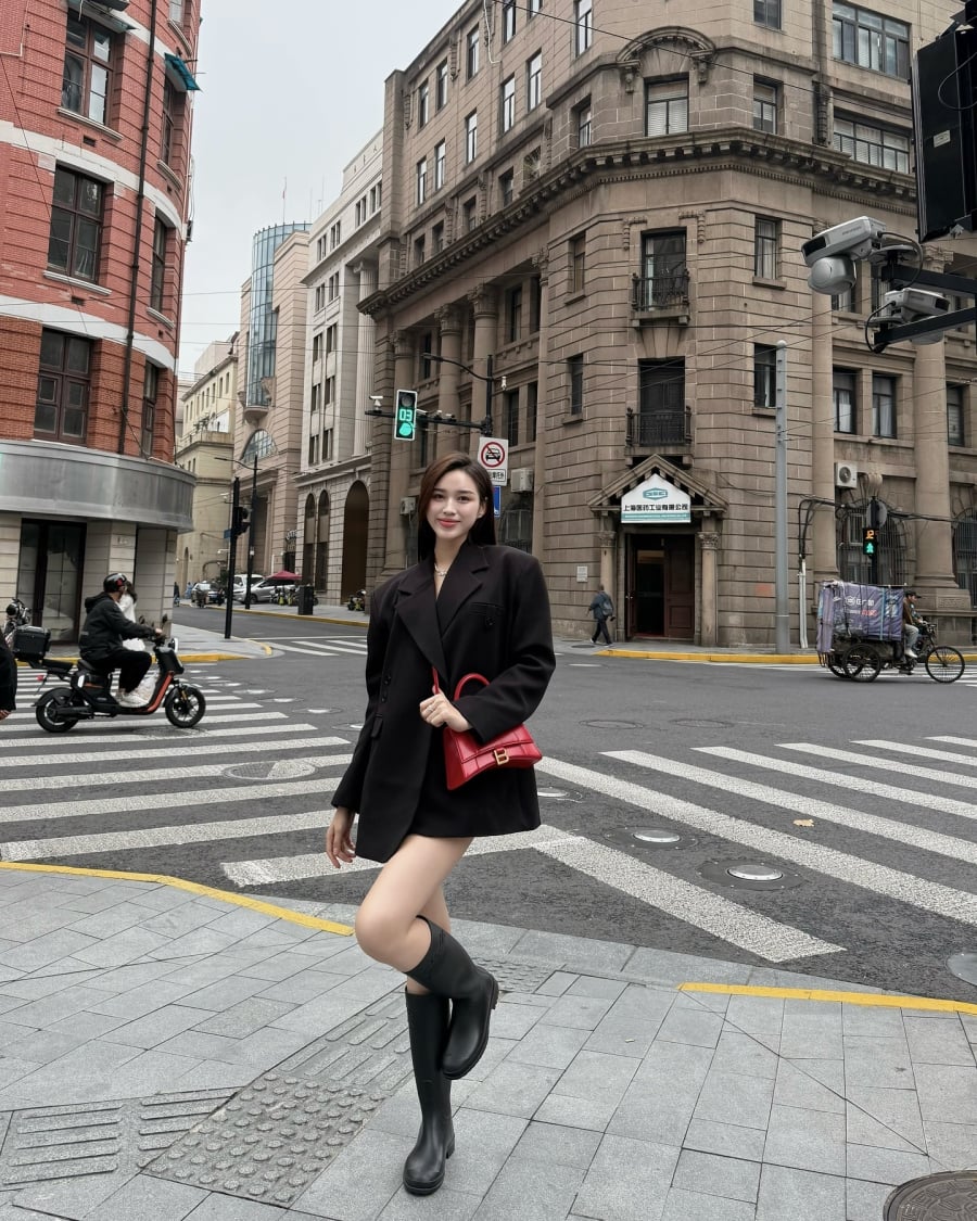 Boots cao cổ và chiếc túi đỏ là hai chi tiết giúp outfit của cô thêm sắc sảo mà vẫn đúng tinh thần mùa lạnh.