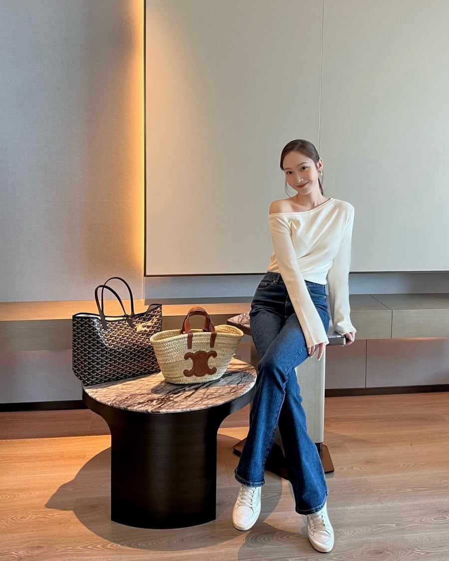 Jessica làm mới combo quen thuộc gồm áo thun trắng và quần jeans xanh bằng cách chọn kiểu áo lệch vai và sơ vin gọn gàng. 