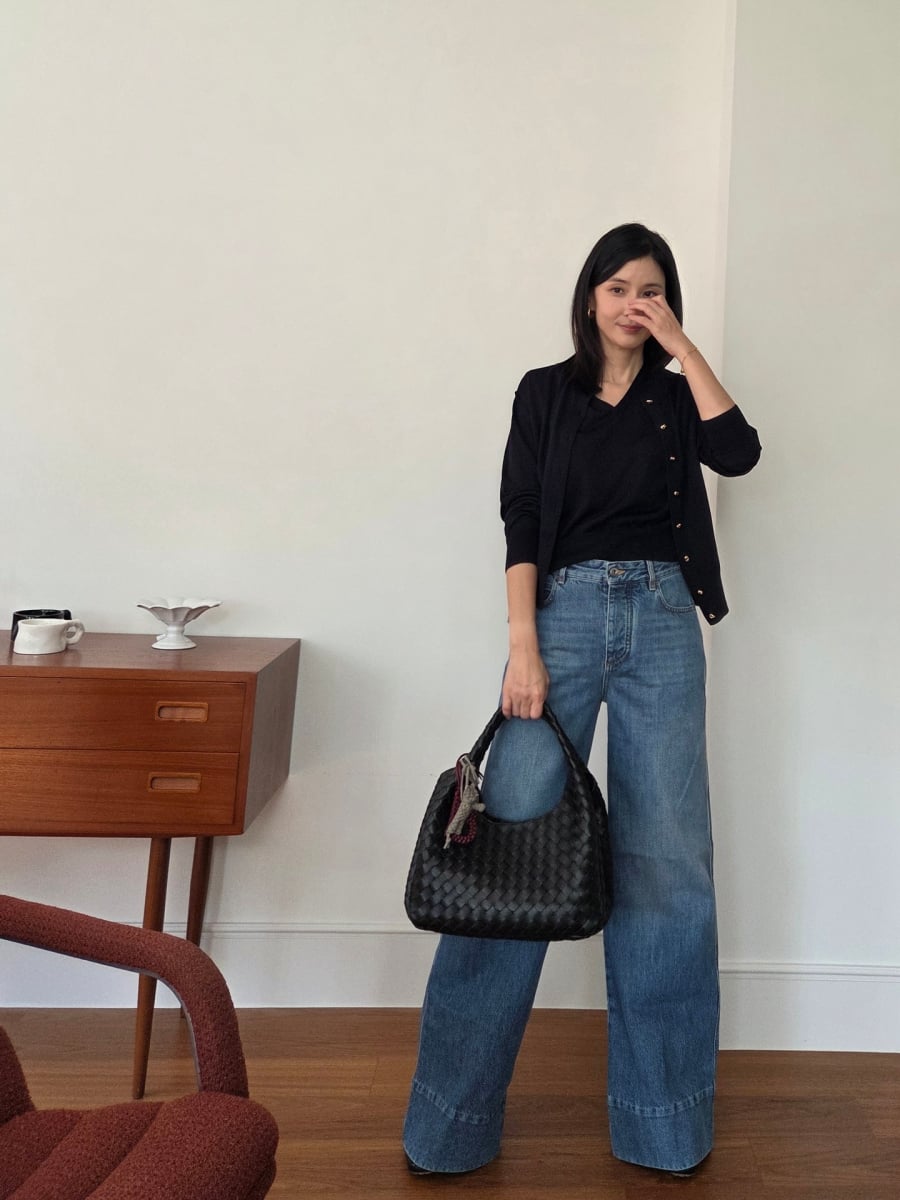 Thao tác sơ vin gọn gàng cùng phụ kiện màu trung tính như túi xách và giày đen giúp bộ đồ giữ được sự tinh tế cần thiết cho phụ nữ U50.