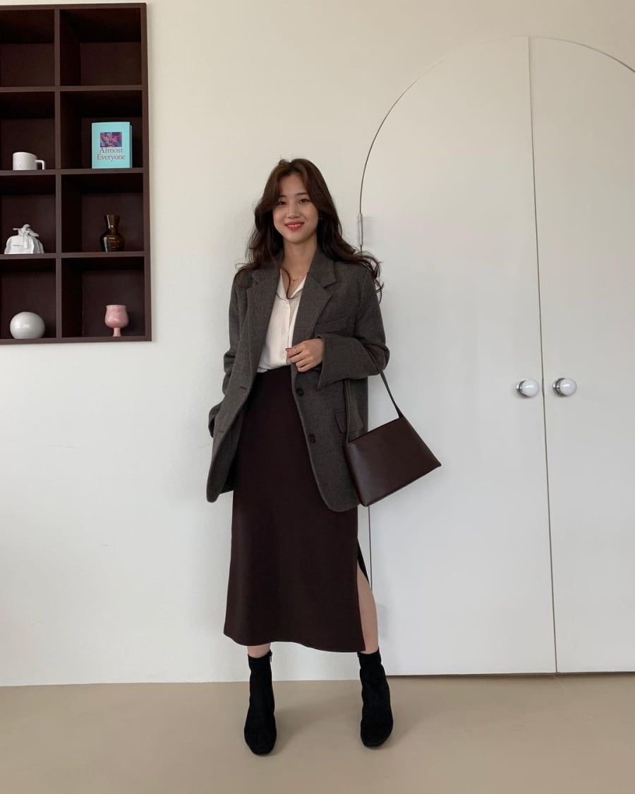 Sự kết hợp giữa phom dáng cứng cáp của blazer và nét mềm mại của chân váy tạo nên diện mạo chuyên nghiệp nhưng không hề khô cứng.