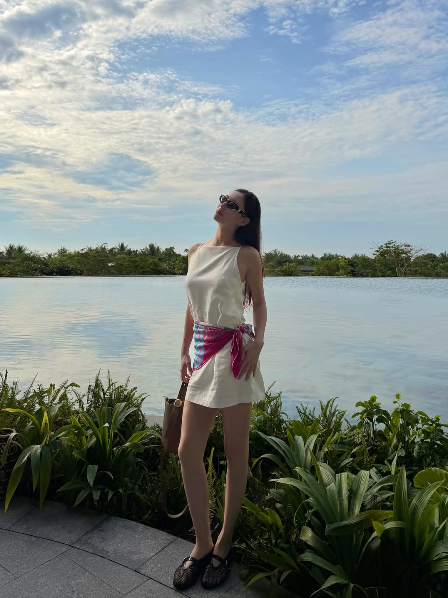 Chiếc váy trắng không tay với đường cắt may gọn gàng là minh chứng rõ nét cho phong cách tối giản mà cô theo đuổi.