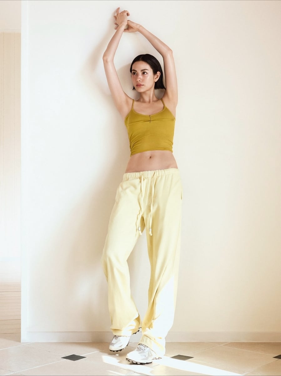  Áo hai dây dáng crop màu xanh olive kết hợp quần jogger màu vàng kem và giày thể thao trắng mang đến hình ảnh khỏe khoắn nhưng vẫn rất hợp xu hướng.