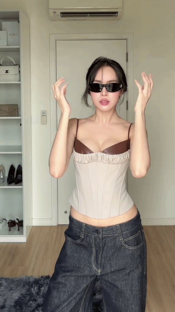 Một trong những set đồ gây chú ý gần đây là sự kết hợp giữa áo corset màu kem ôm sát Sh88bet đăng ký miễn phí và quần jeans ống rộng màu tối.