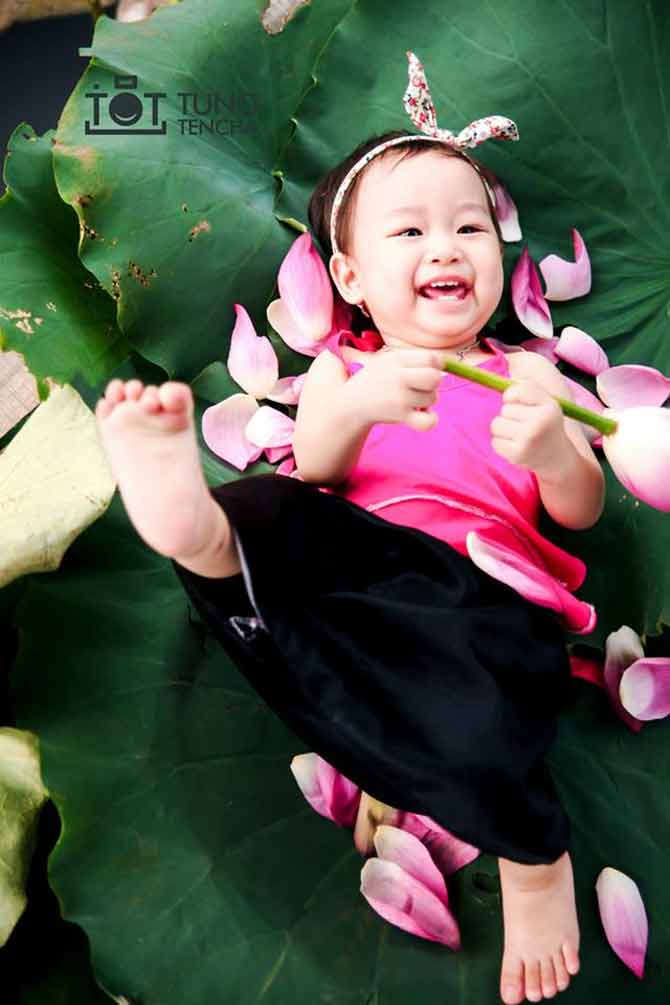 Nụ cười giòn tan của bé khi đùa nghich với sen.