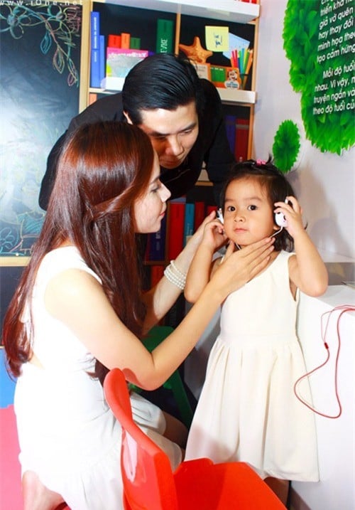 Thiên thần nhỏ đang được bố mẹ đeo giúp tai nghe.