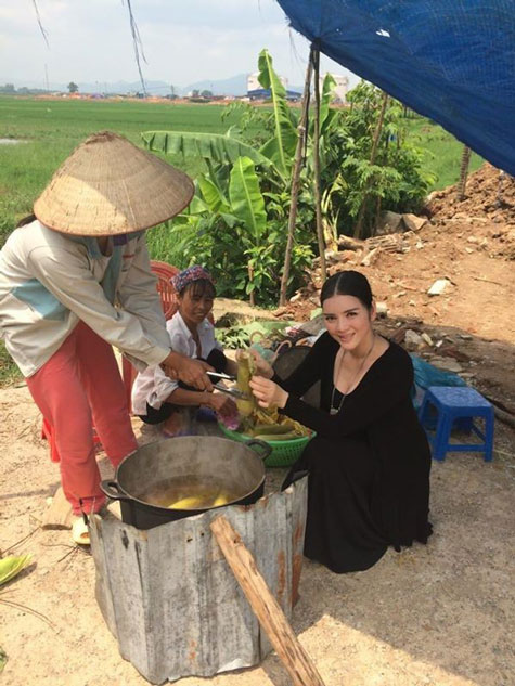 Lý Nhã Kỳ ngồi ven đường ăn ngô luộc.