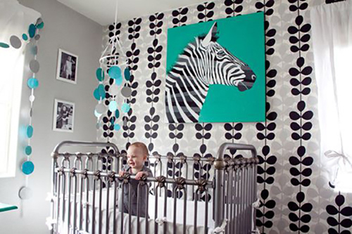 Màu ngọc lam kết hợp với giấy dán tường hoa lá màu ghi xám, chiếc nôi bằng sắt với hoa văn cổ điển.