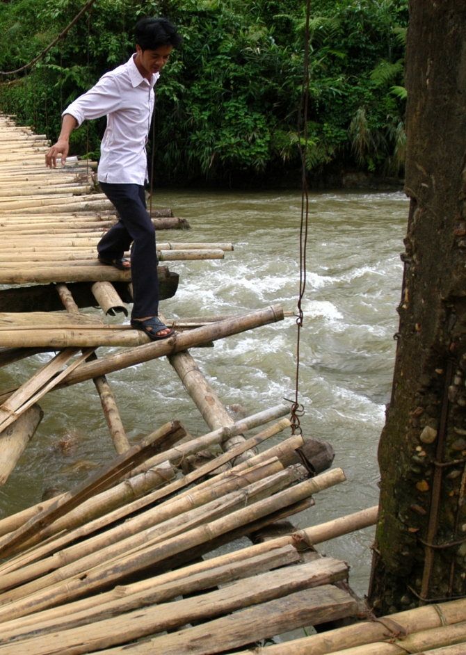 Mặt ván lát cầu đã mục và hỏng hết nên người dân địa phương đành dùng tre nứa ghép lại.