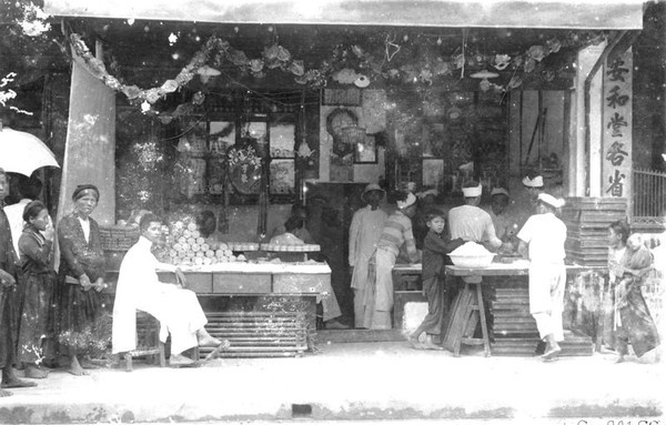 Trẻ con tò mò nhìn những người thợ làm bánh Trung thu.