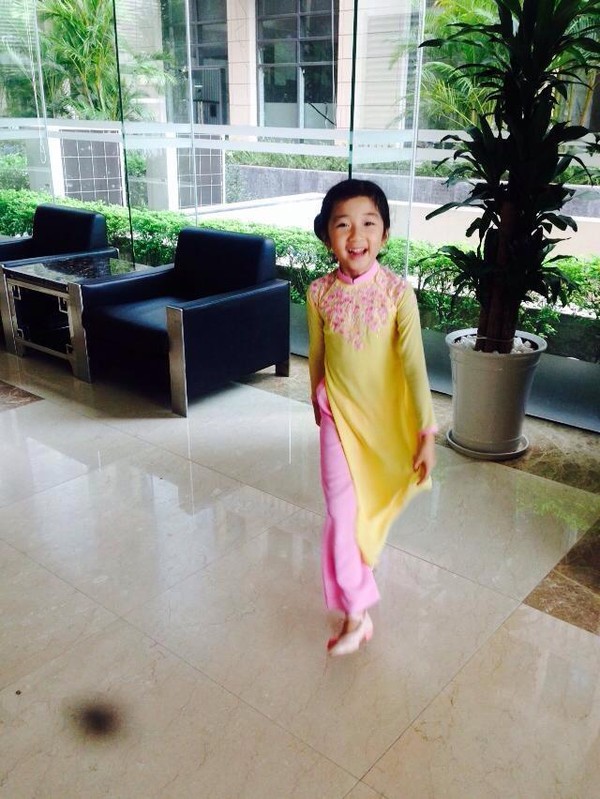 Dường như Khánh Linh đã được hưởng gen nghệ thuật của mẹ từ rất sớm. Cô bé điệu đà tạo dáng trong tà áo dài để mẹ chụp ảnh.