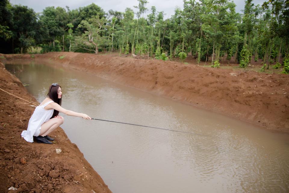 Khánh My mặc đồ trắng sành điệu ngồi câu cá.