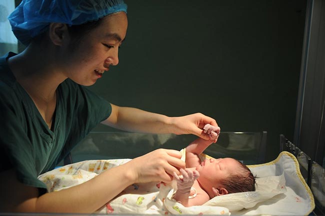 Em bé đang được vệ sinh và kiểm tra các phản xạ thông thường.