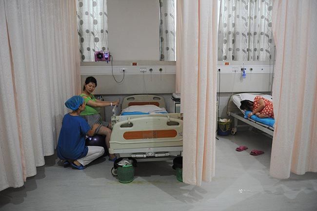 Phòng chờ sinh ở Trung Quốc cũng có khoảng 3-4 giường, được ngăn cách bởi cách tấm rèm kéo bằng vải mỏng. Trong phòng chờ sinh, thai phụ 9x Guo Jia đang bắt đầu được y tá hướng dẫn ngồi trên quả bóng sinh để luyện tập