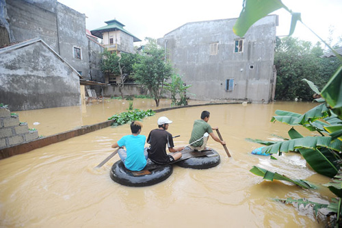 Anh Hùng phải đi băng phao vào nhà vì nhà anh đã bị ngập sâu, cả nhà anh đã sơ tán đi chỗ khác còn anh ở nhà trông nhà.