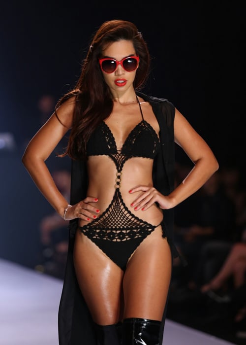 Cô sải bước tự tin trên sàn diễn trên đôi boots cao cổ cùng áo khoác nhẹ cho bộ bikini ren đen vô cùng gợi cảm.