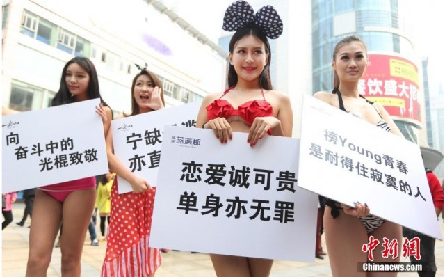 Tại Nam Ninh, một số nhân viên bất động sản đã xuống đường với phong cách thời trang khá mát mẻ: nam để trần, nữ mặc bikini.